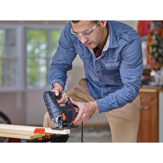 4 A Corded Jigsaw being used by person to cut wood.