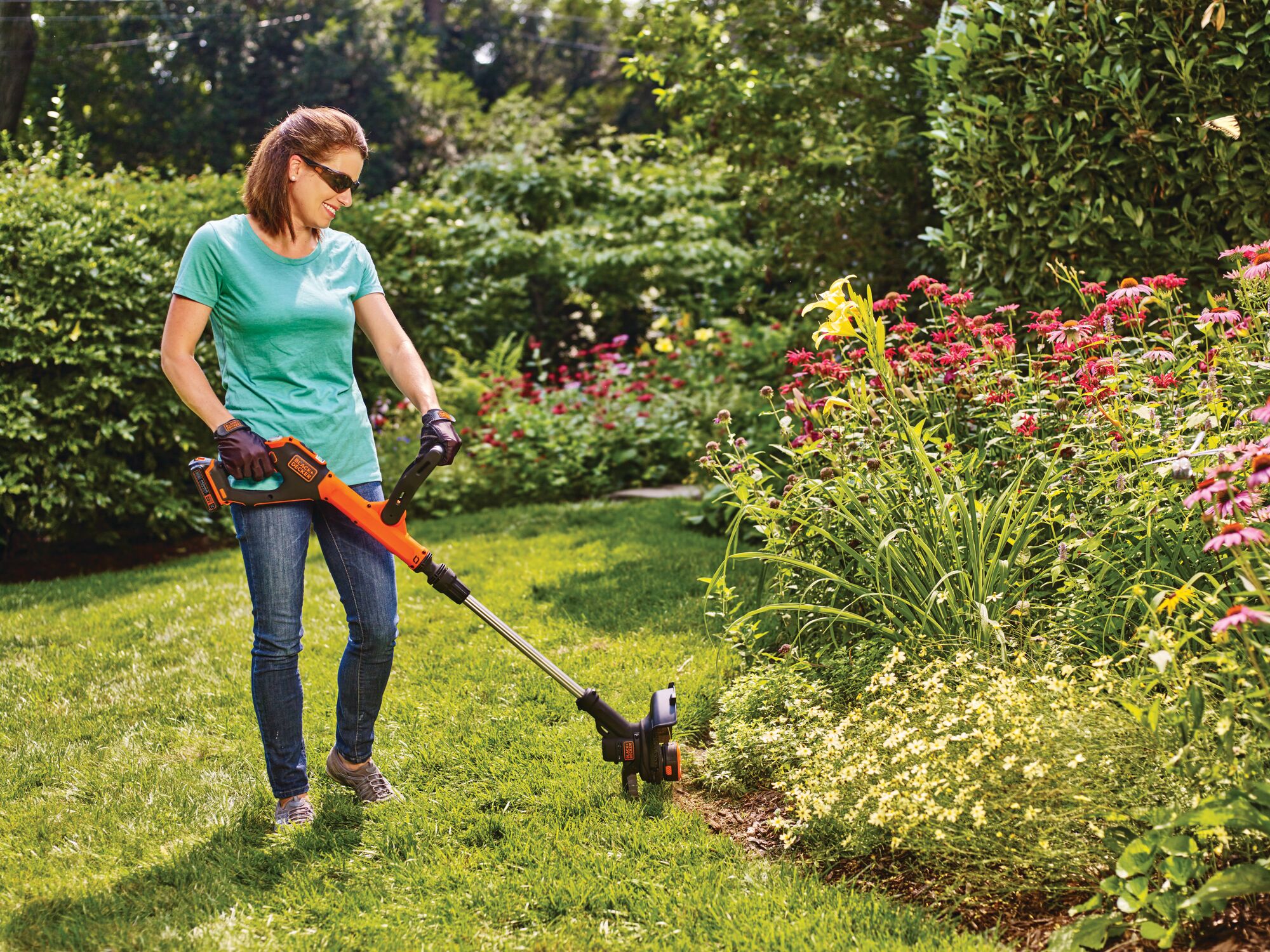 20 volt MAX Lithium EASYFEED String Trimmer / Edger  2 Lithium Ion Batteries  being used by a person outside on grass.